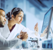 two people in lab coats looking at computer screen
